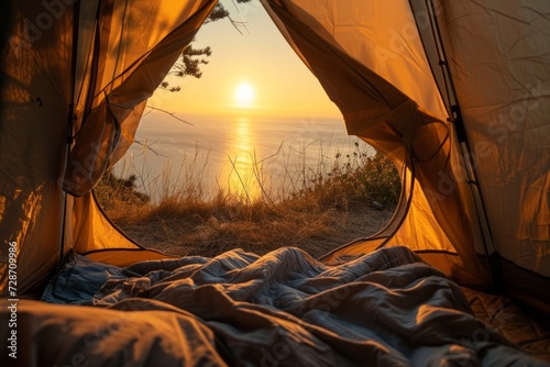 View from inside an open camping tent from the sleeping place to the beautiful sea or ocean landscape at sunrise. Concept of mountaineering, tourist recreation and sport