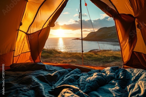 View from inside an open camping tent from the sleeping place to the beautiful sea or ocean landscape at sunrise. Concept of mountaineering, tourist recreation and sport