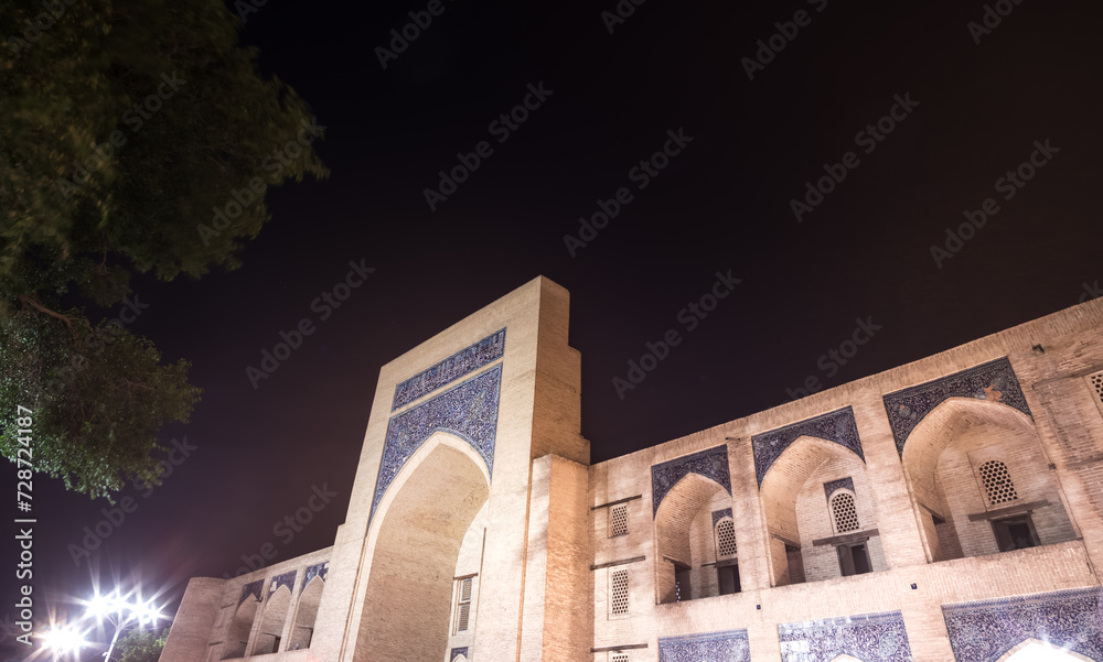 Obraz premium Nodir Devonbegi Madrasah in the ancient city of Bukhara in Uzbekistan in the evening, exterior of the Nodir Devonbegi Madrasah