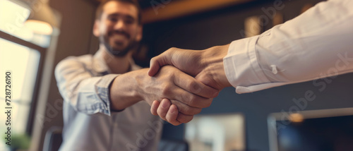 A firm handshake in a warmly lit office captures a moment of professional agreement and mutual respect