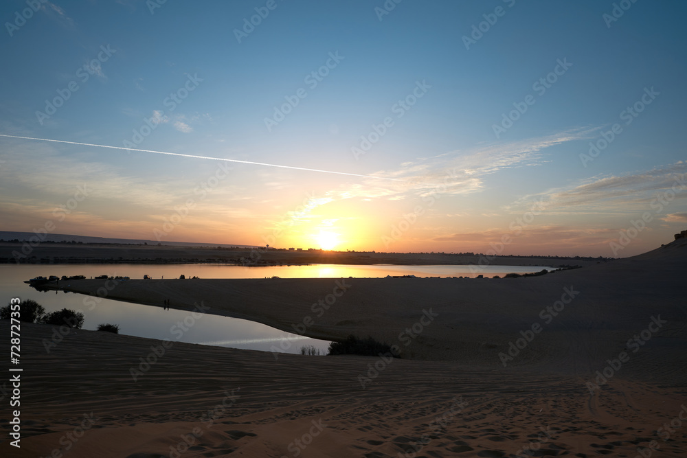 sunset scene on Magic Lake where water comes out of deep earth forms a lake in a heart of dessert in fayoum, Egypt. sunset scene on Magic Lake where water comes out of deep earth forms a lake in a heart of dessert in fayoum, Egypt.