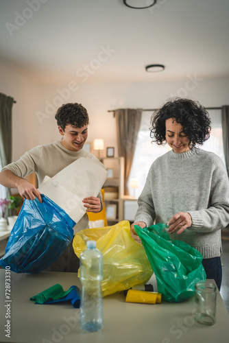 mother and son recycle at home sorting waste plastic paper and glass