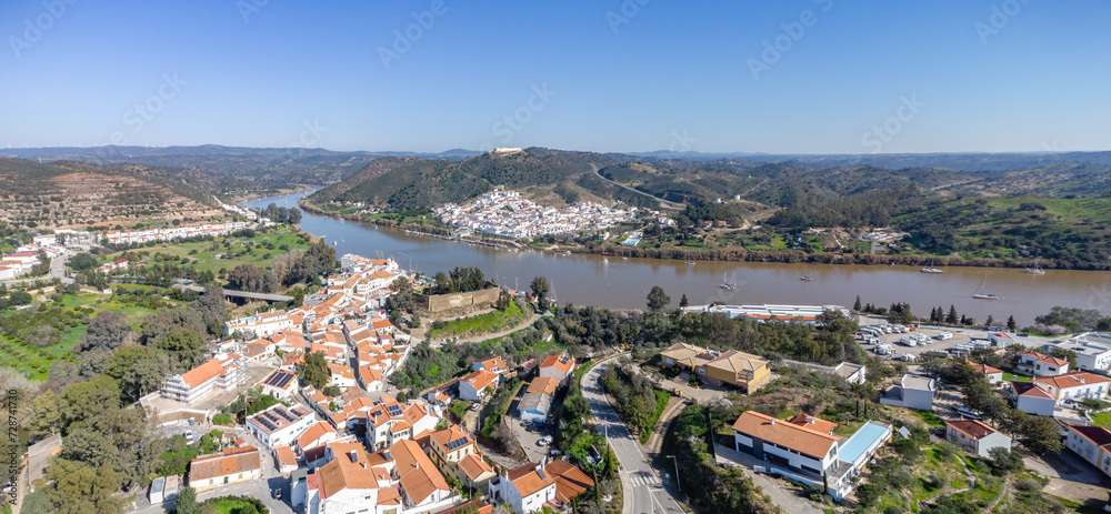 Aerial view of the border village of Alcoutim in Algarve, Portugal, with the Castle (Castelo de Alcoutim) on the banks of Guadiana river, with Sanlucar de Guadiana in the far view, Andalusia, Spain