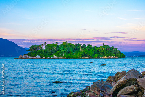 Tropical Forest Island at the morning viwed from the mainland beach at the morning with a purple sky photo