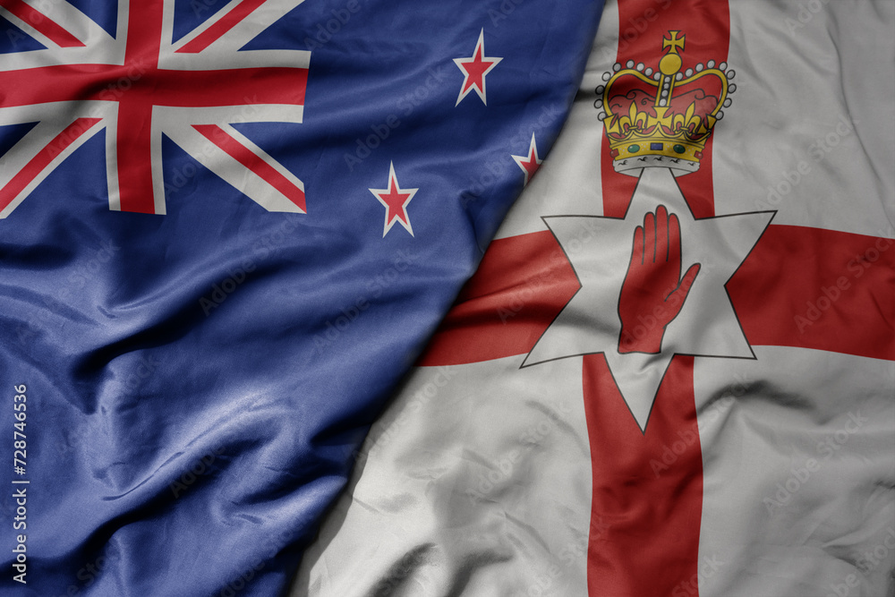 Fototapeta premium big waving national colorful flag of northern ireland and national flag of new zealand .