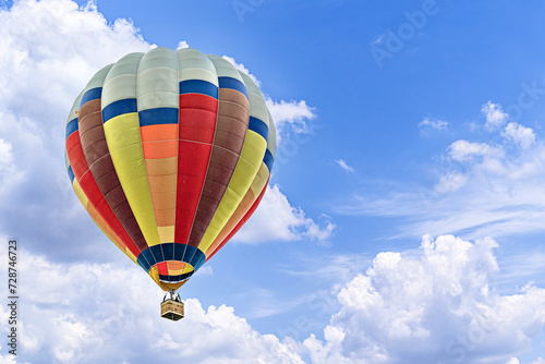 Colorful hot air balloon flying over blue sky with white clouds  © Toni