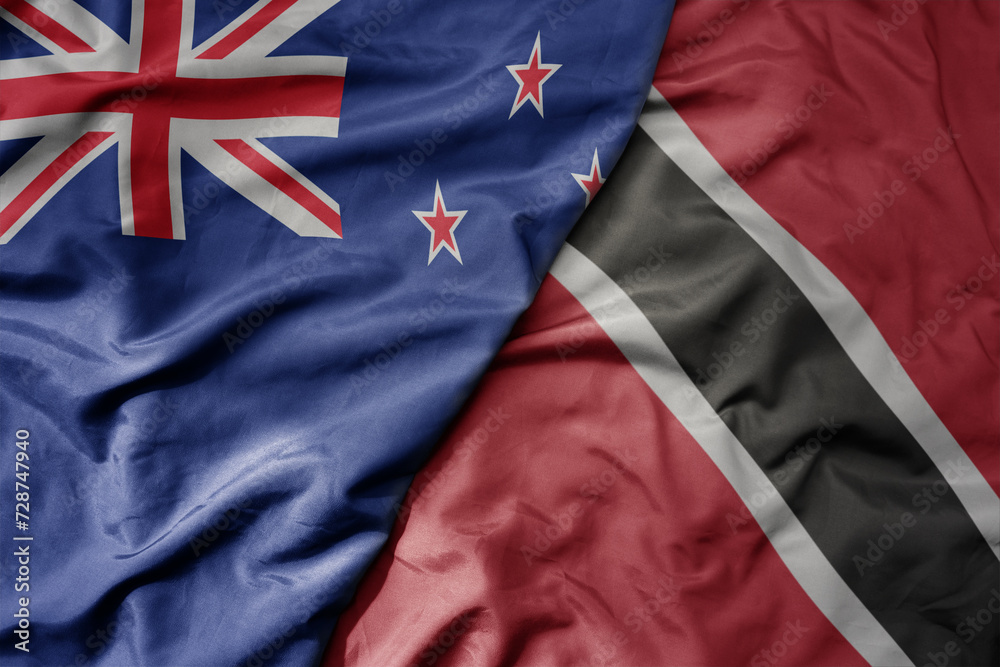 Fototapeta premium big waving national colorful flag of trinidad and tobago and national flag of new zealand .