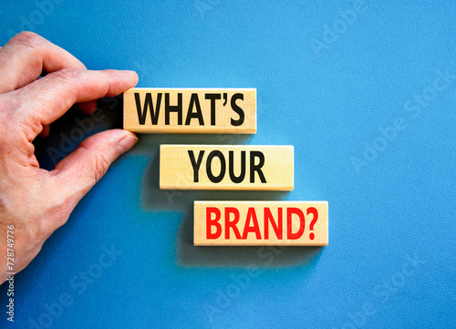 Branding and what is your brand symbol. Concept words What is your brand on beautiful blocks. Beautiful blue background. Businessman hand. Business branding what is your brand concept. Copy space.