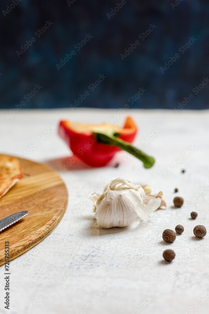 Pieces of allspice, sweet pepper, and garlic are scattered on the table. Cooking process Pieces of allspice, sweet pepper, and garlic are scattered on the table. Cooking process