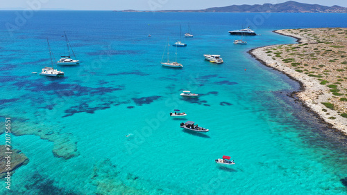 Aerial drone photo from tropical exotic paradise secluded rocky island bay with deep turquoise and sapphire sea forming a blue lagoon visited by yachts and sailboats in Caribbean exotic destina