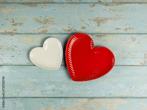 Heart shaped plates on vintage wooden background. Top view.