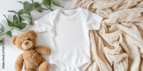 White cotton baby short sleeve bodysuit, teddy bear and natural wooden toy on beige blanket throw background. Infant onesie mockup. Blank gender neutral newborn bodysuit mock up template. Top view photo