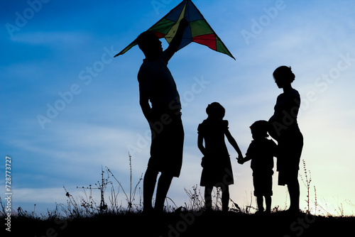 Happy family playing on nature summer silhouette