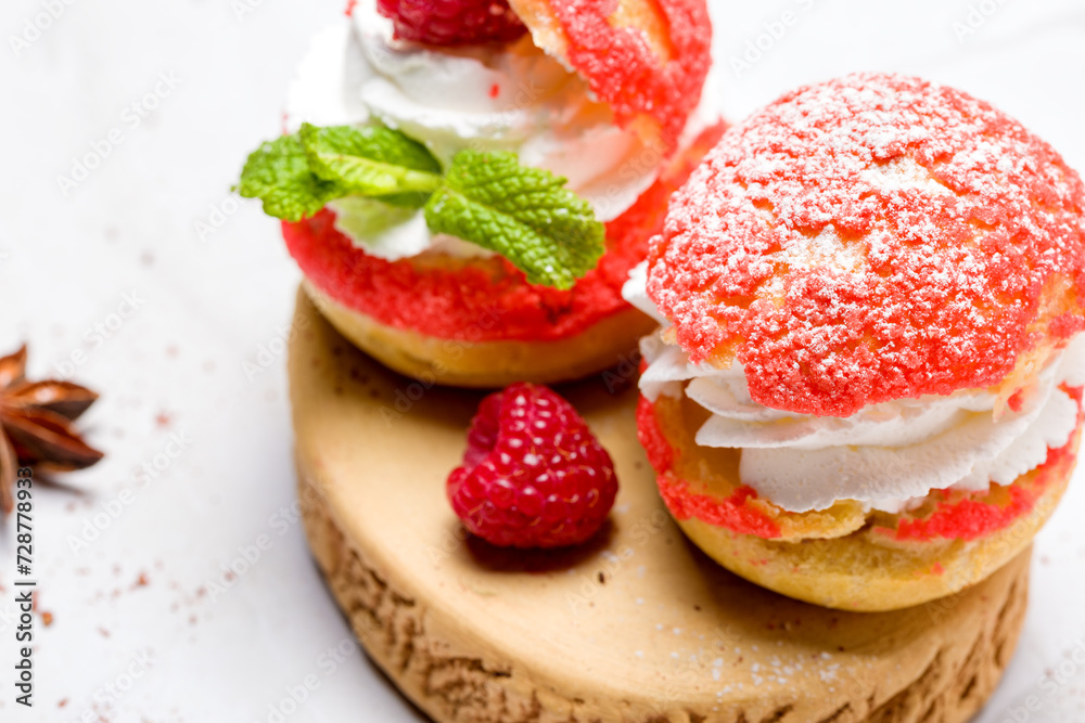 Shu cake. Custard dessert with creamy white cream, decorated with raspberries Shu cake. Custard dessert with creamy white cream, decorated with raspberries