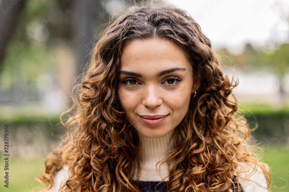 portrait of beautiful curly haired woman looking at camera portrait of beautiful curly haired woman looking at camera