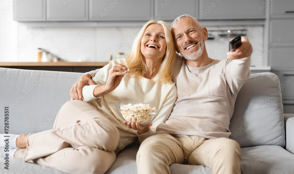 Joyful old man and woman couple watching TV at home Joyful old man and woman couple watching TV at home