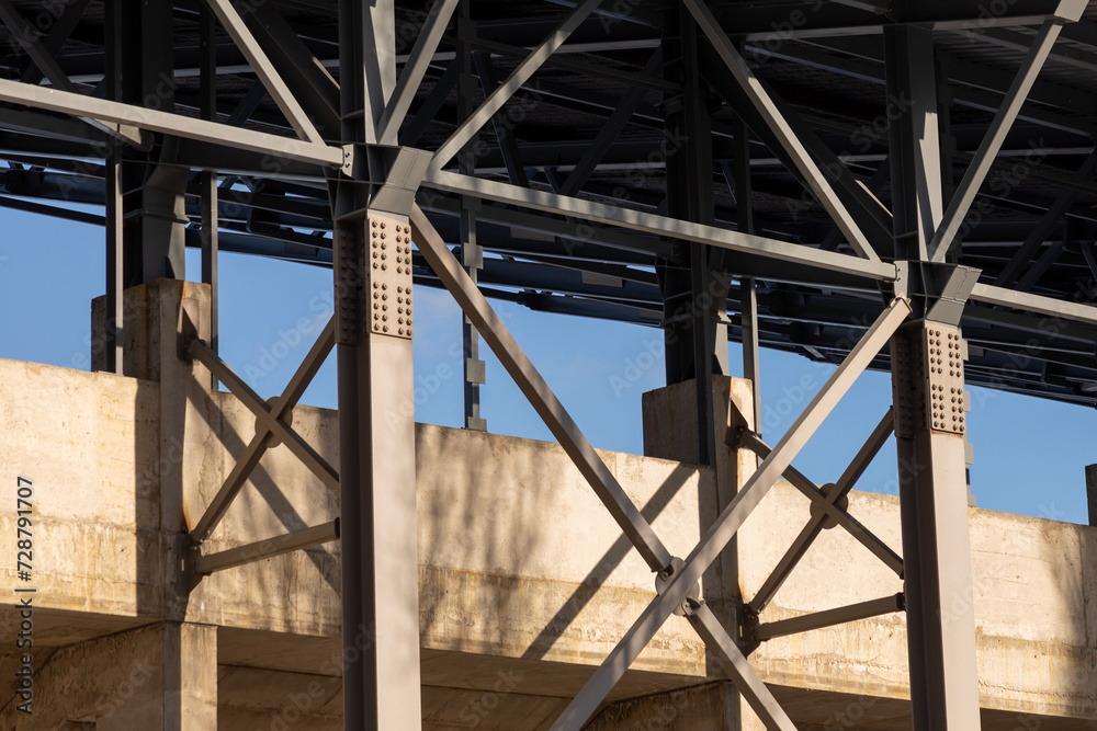 Metal structures, Industrial building. Concrete pillars with bolted connections of metal support structures and roof of industrial building