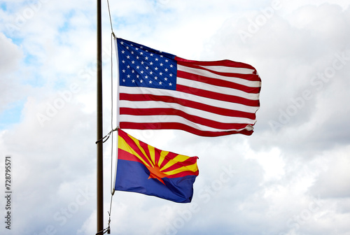 American flag and Arizona State Flag on a flag pole blowing in the wind