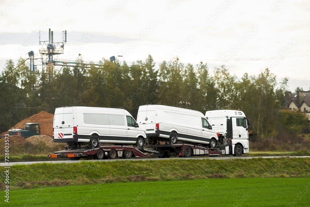 A tow truck carries a broken car on the highway in bad weather. Roadside assistance helps a driver in trouble. Rollback tow truck. A tow truck carries a broken car on the highway in bad weather. Roadside assistance helps a driver in trouble. Rollback tow truck.