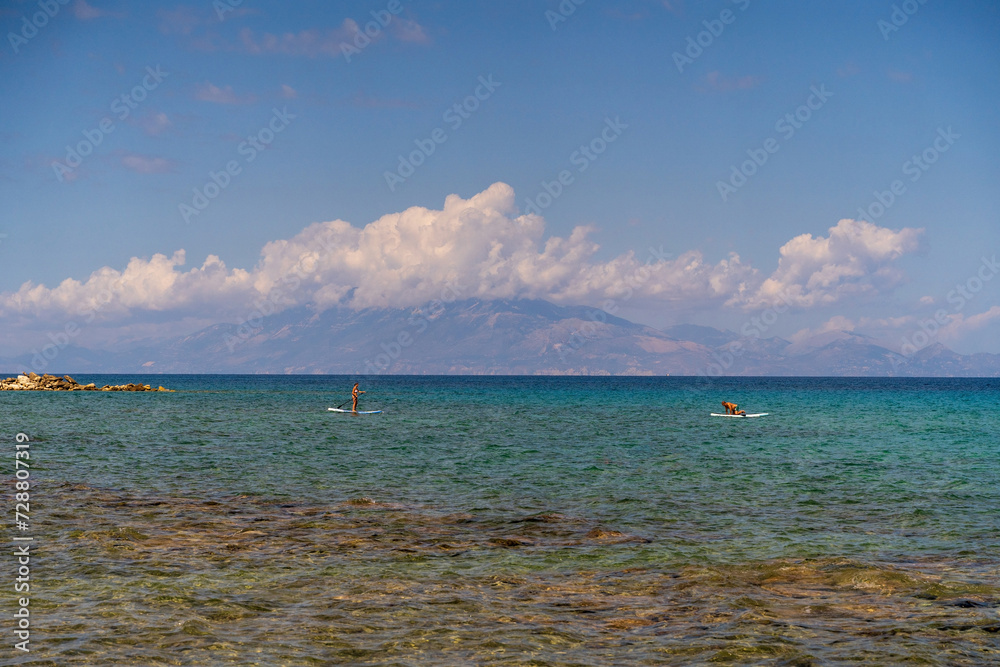 Zakynthos, Greece - August 01, 2020: Tourist doing Paddle board kayaking in mediterranean sea in Zakynthos island of Greece