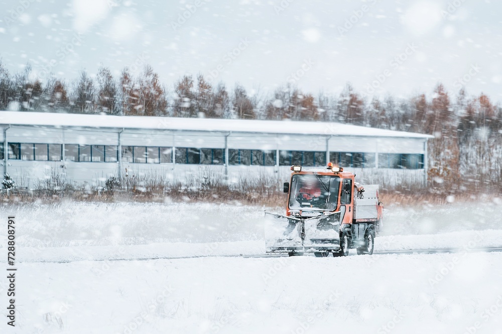 Tractor with mounted salt and sand spreader, road maintenance - winter gritter vehicle. Municipal service melting ice and snow on streets. Diffusing salt blend on public roads. Tractor with mounted salt and sand spreader, road maintenance - winter gritter vehicle. Municipal service melting ice and snow on streets. Diffusing salt blend on public roads.