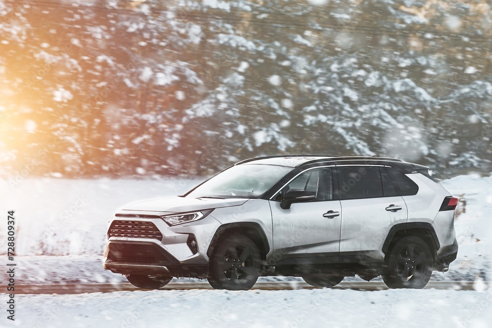 Winter’s embrace holds no barrier for this powerful SUV as it glides through the snowy terrain with grace and power showcasing man’s conquest over nature. White truck car on the winter snowy road.