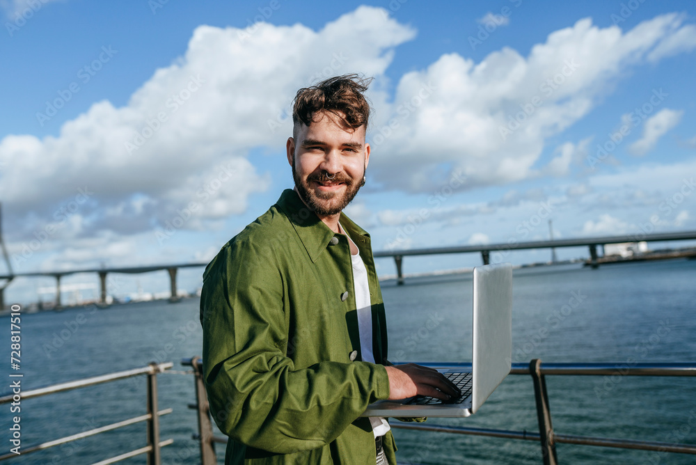 Fototapeta premium Man using laptop by the sea