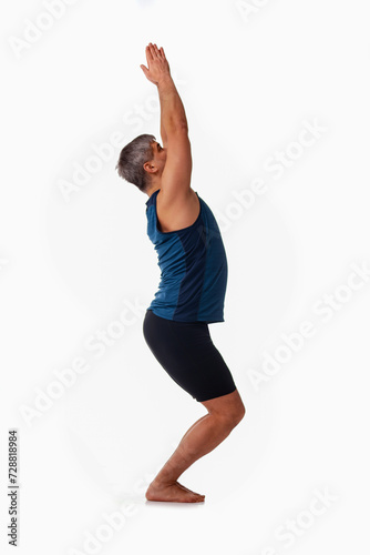 Vinyasa, Ashtanga yoga  Side view of man wearing sportswear doing Yoga exercise against white background. © zwiebackesser