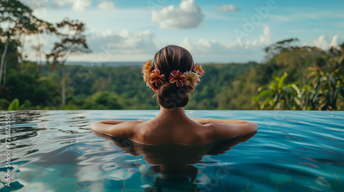 Junge Frau mit Blumen im Haar entspannt sich in einem Schwimmbad.