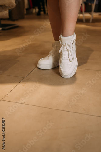 The image shows a persons legs wearing white shoes 6080.