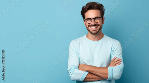 Portrait of young smiling man wearing glasses isolated on turquoise background with space for inscriptions or text photo