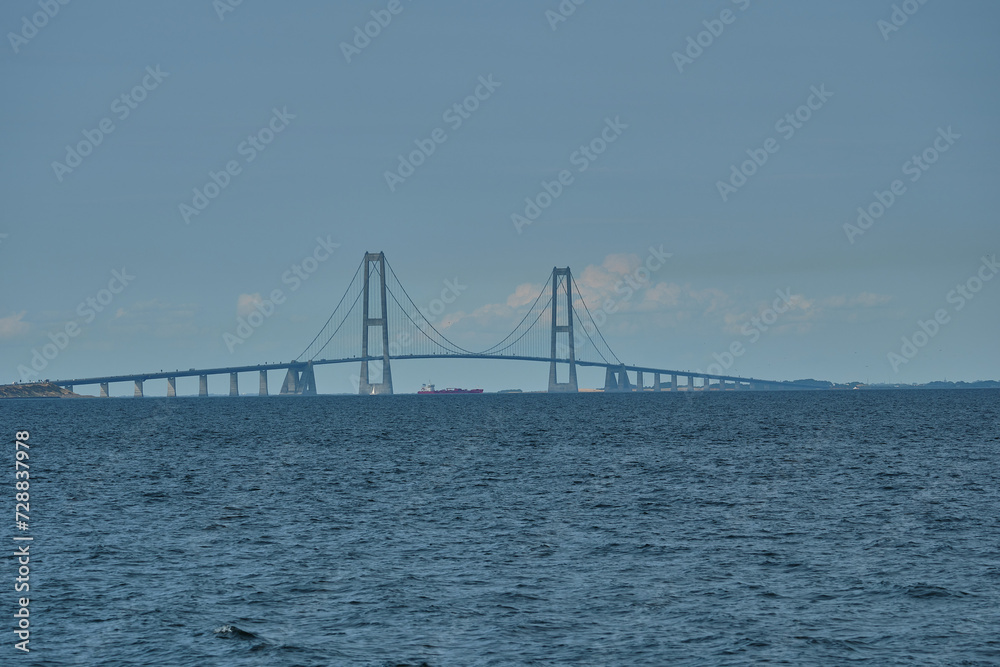 great Storebelt suspension bridge connecting Denmarks islands across the baltic sea on a hazy sunny day.