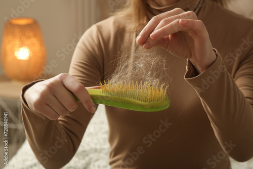 Woman holding detangler hair brush full of hair that has fallen out, loss hair problem  photo