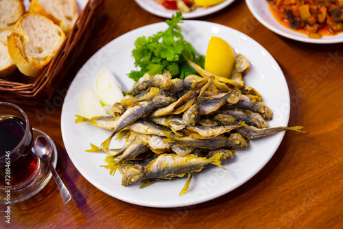 Dietary mullet fish. Fried fish in a plate with parsley and lemon. Turkish cuisine
