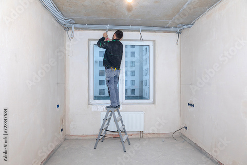 Electrical worker checks voltage in wires. Repair in new apartment, electricity wiring. High quality photo