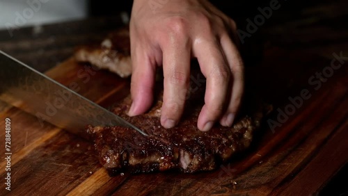 chef cutting beef steak with knife