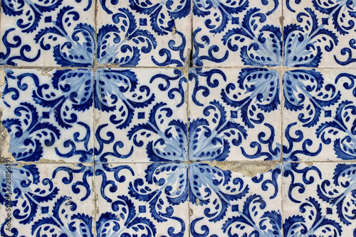 Closeup of decorative floral tiles. Blue traditional Portuguese ceramic tile pattern, azulejos. Beautiful shabby facade, wall decoration of old Lisbon building, Portugal. Decorative background.