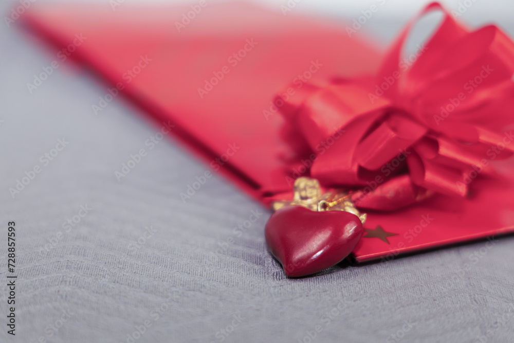 A gift in a red package with a heart and an angel. Valentine's day concept. A gift in a red package with a heart and an angel. Valentine's day concept.