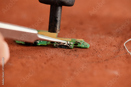 partial view of experienced technician desoldering electronic chip in repair workshop, banner photo