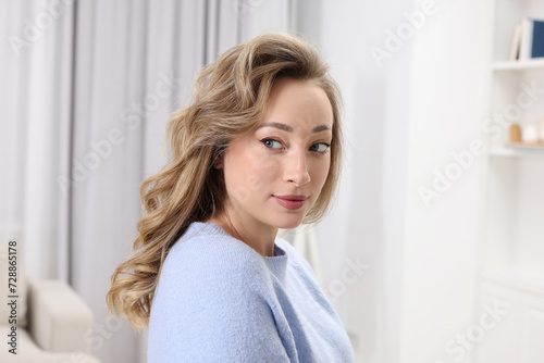 Portrait of beautiful woman with curly hair at home