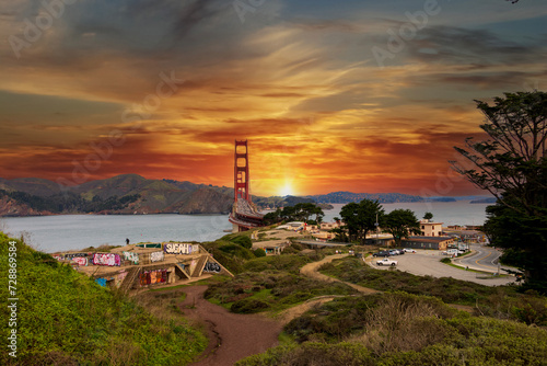 The Golden Gate Bridge over the bay with mountains and lush green trees, plants and grass at the Presidio National Park in San Francisco California USA
