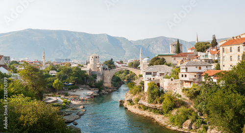 Old bridge in old town of Mostar at sunny day, Bosnia and Herzegovina. Tourist background for publication, design, poster, calendar, post, screensaver, wallpaper, cover, website. High quality photo