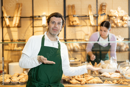 Focused male bakery worker showing around his workplace