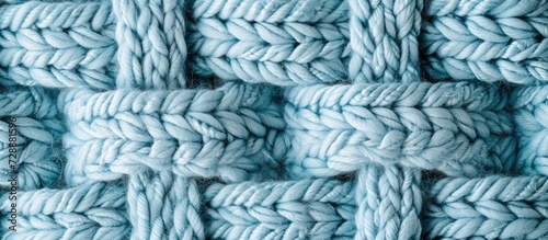 Top view of a knitted plaid with a soft light blue background.