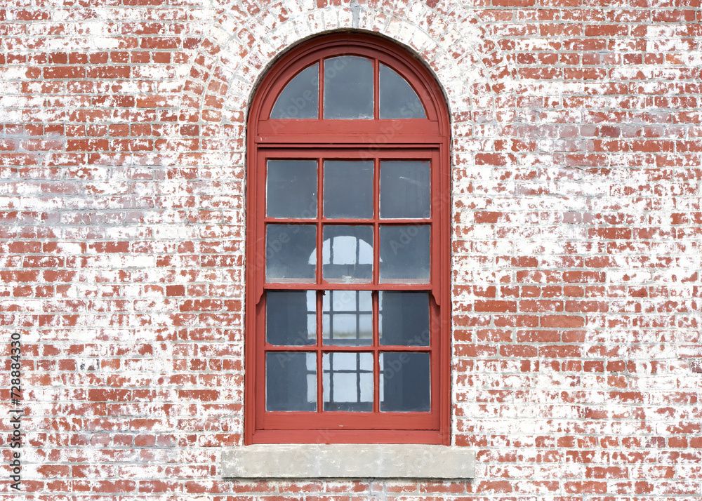 Obraz premium Red framed window inside a window with old red brick facade.