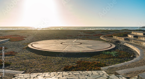 Circle platform at the beach in a sunset with the sun and sea at the background