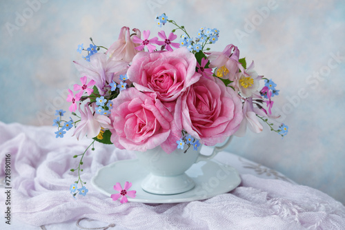 Bouquet of spring and summer flowers in a cup on the table  rose  aquilegia  forget me not flowers  beautiful postcard  still life  blur.
