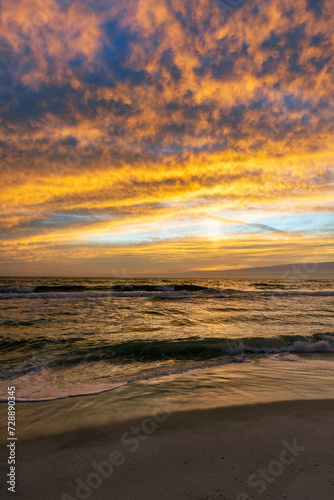 Vertical image of dusk over the gulf with the sky set ablaze.