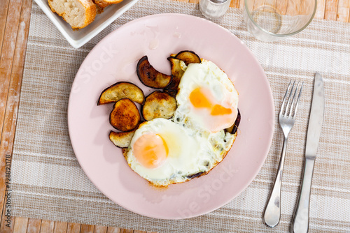 Image of a appetizing fried eggs, cooked with sliced roasted eggplant photo