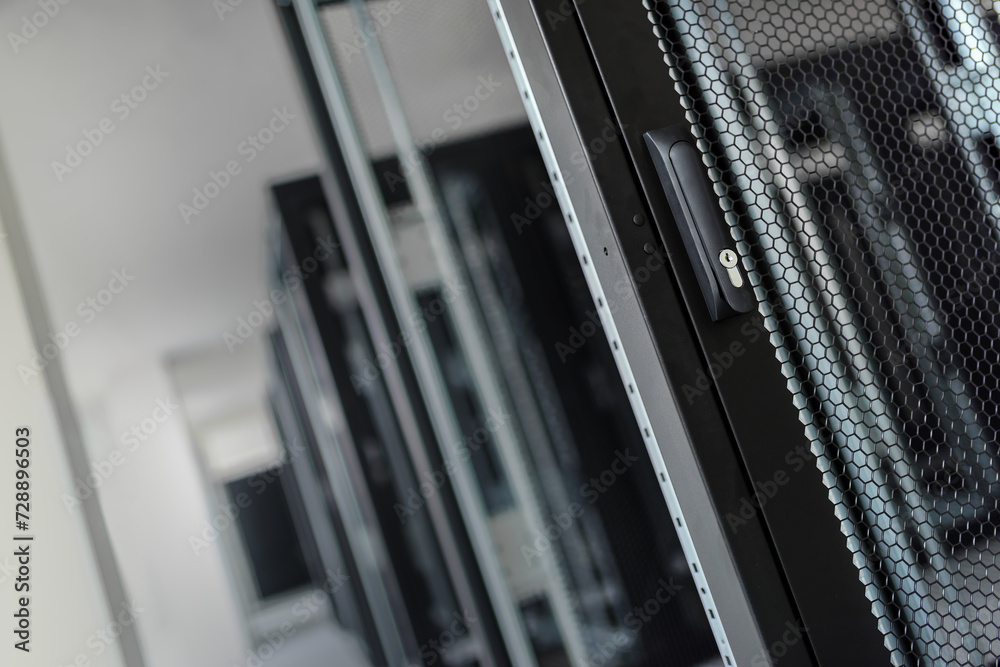 A close-up view of the door handle of an empty server rack. A close-up view of the door handle of an empty server rack.